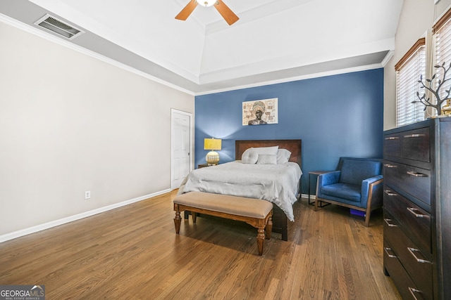 bedroom with baseboards, visible vents, a ceiling fan, wood finished floors, and crown molding