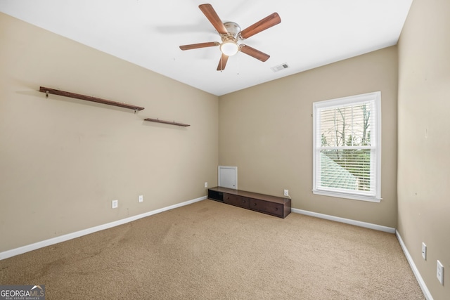 carpeted empty room with a ceiling fan, visible vents, and baseboards