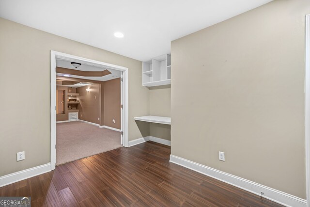 spare room featuring dark wood-type flooring, recessed lighting, and baseboards