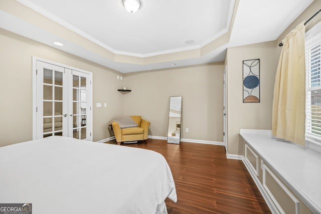 bedroom featuring baseboards, dark wood finished floors, a tray ceiling, crown molding, and french doors