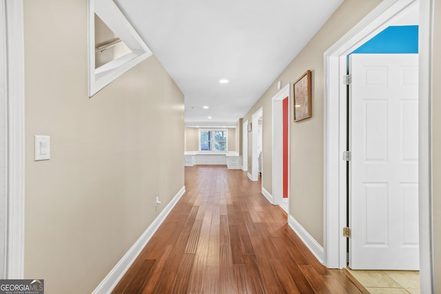 corridor featuring recessed lighting, baseboards, and wood finished floors