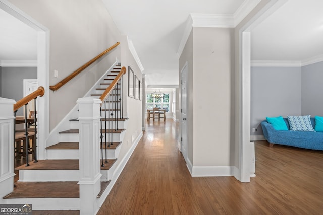 stairs featuring baseboards, ornamental molding, and wood finished floors