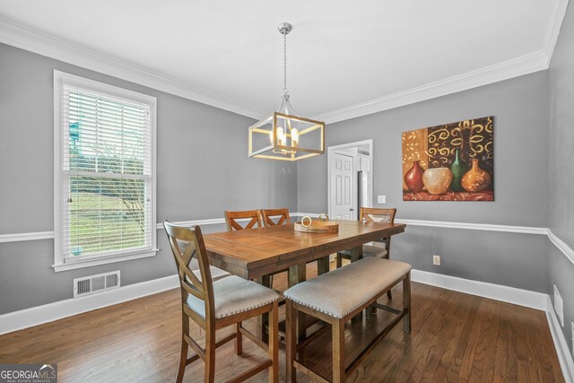 dining room with baseboards, visible vents, wood finished floors, and ornamental molding