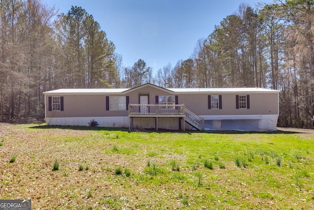 manufactured / mobile home featuring a deck and a front lawn