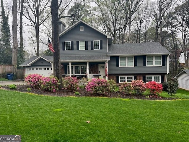 tri-level home with a garage, a front lawn, and a porch