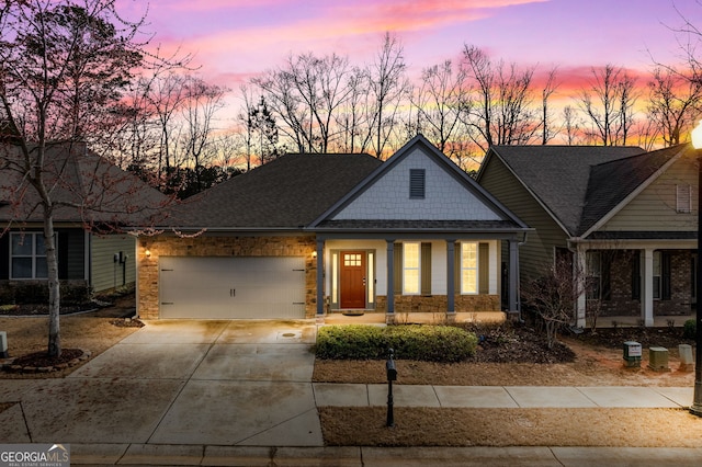 craftsman-style house with covered porch, driveway, and an attached garage