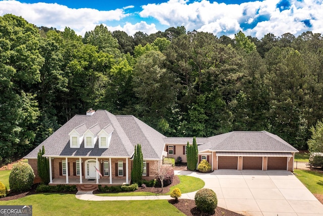 view of front of home featuring a garage, a front yard, and covered porch