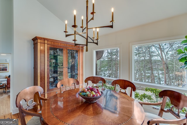 dining area with hardwood / wood-style flooring and vaulted ceiling