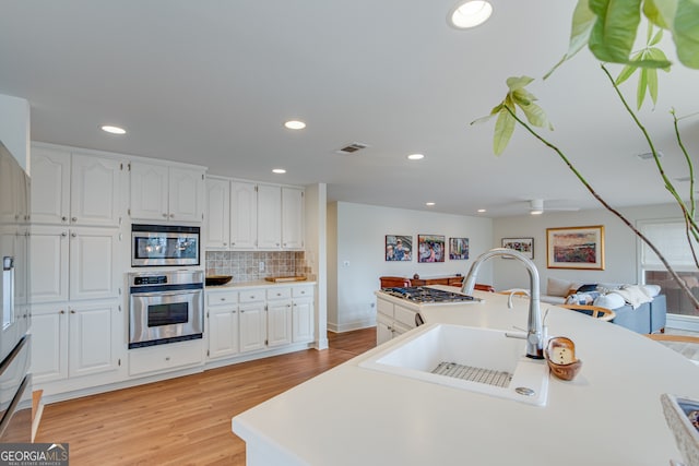 kitchen featuring white cabinetry, sink, tasteful backsplash, and stainless steel appliances