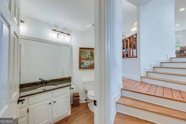 bathroom featuring vanity, hardwood / wood-style flooring, and toilet