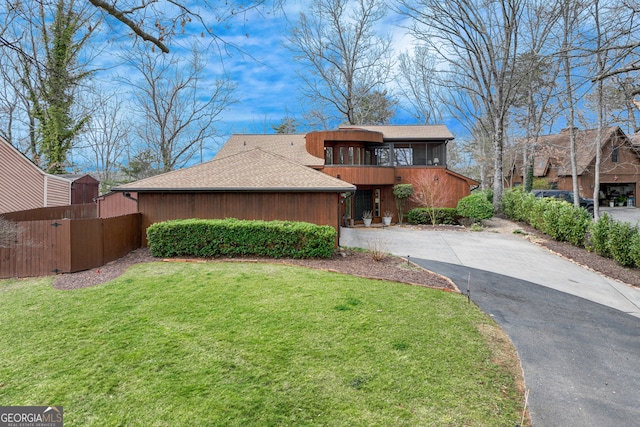 view of front of house with a front lawn and a sunroom