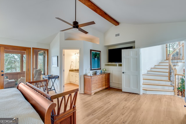 interior space featuring ceiling fan, lofted ceiling with beams, and light wood-type flooring