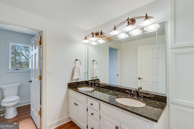 bathroom featuring wood-type flooring, toilet, and vanity