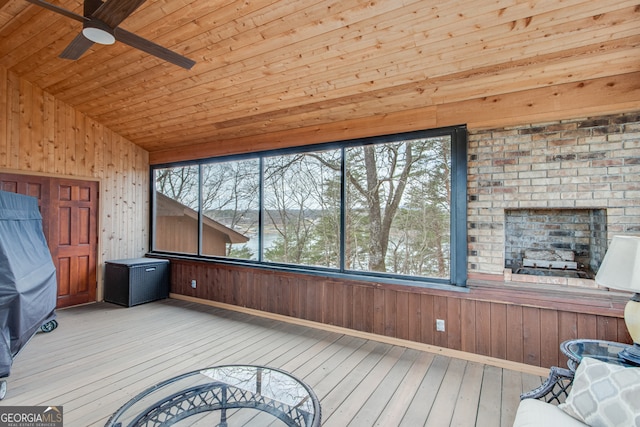 unfurnished sunroom with ceiling fan, vaulted ceiling, and wooden ceiling