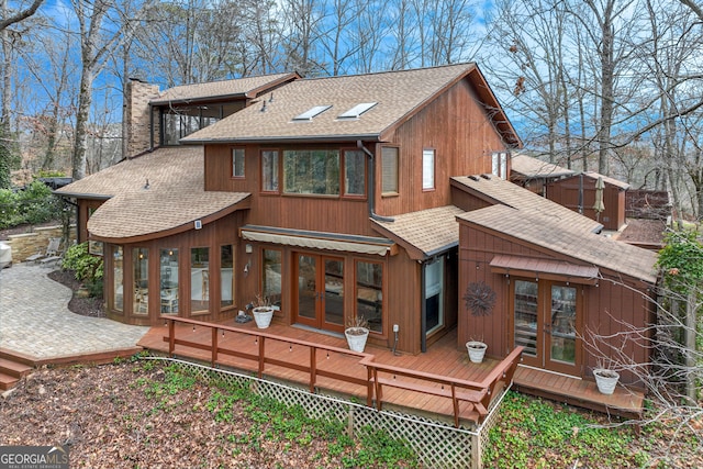 rear view of property featuring a wooden deck and french doors