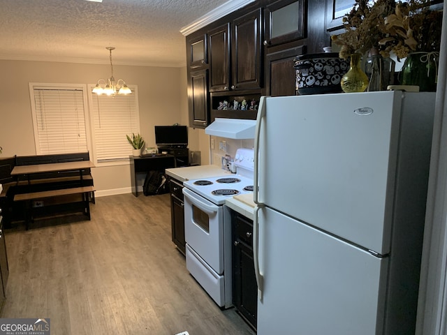 kitchen featuring a textured ceiling, white appliances, light countertops, light wood finished floors, and crown molding