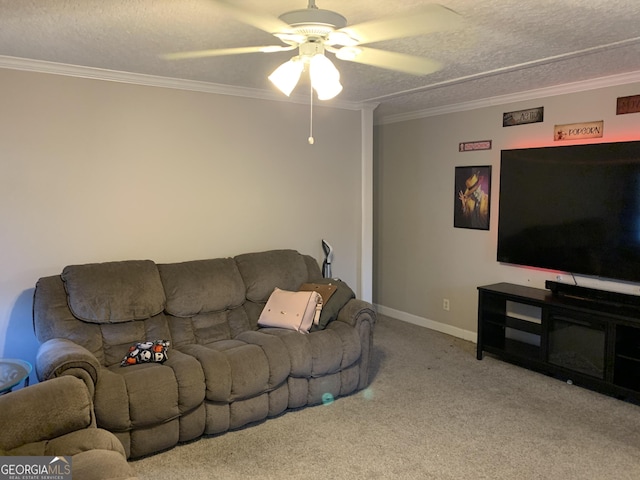 living area featuring ceiling fan, a textured ceiling, baseboards, ornamental molding, and carpet