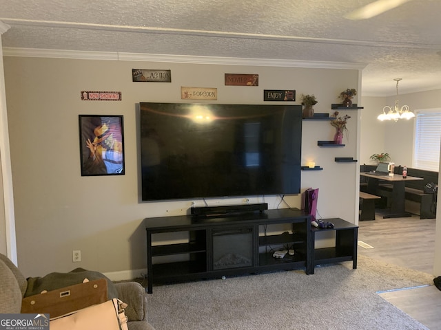 living area with crown molding, a textured ceiling, and a notable chandelier