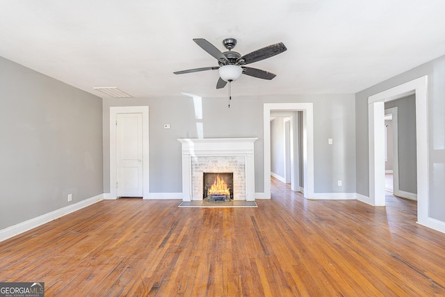 unfurnished living room with wood-type flooring and ceiling fan