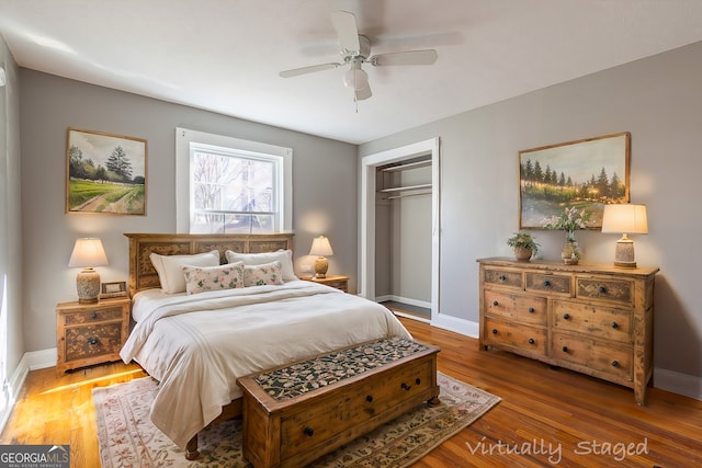 bedroom with wood-type flooring, ceiling fan, and a closet