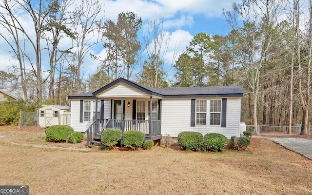 view of front of home with a shingled roof, a front lawn, fence, a porch, and crawl space