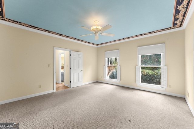 carpeted spare room with ceiling fan and ornamental molding