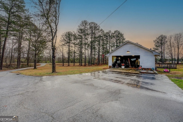 exterior space featuring an outbuilding, a garage, and a lawn