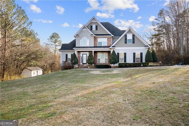 craftsman inspired home with a front lawn and a storage unit