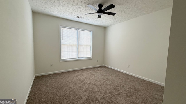 empty room featuring baseboards, visible vents, a ceiling fan, a textured ceiling, and carpet flooring