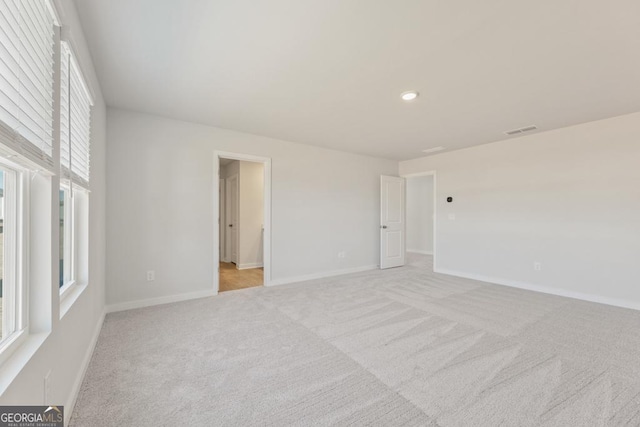 unfurnished bedroom featuring recessed lighting, light carpet, visible vents, and baseboards