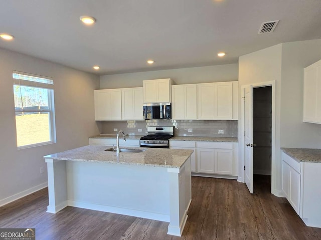 kitchen featuring stainless steel appliances, backsplash, a sink, and visible vents