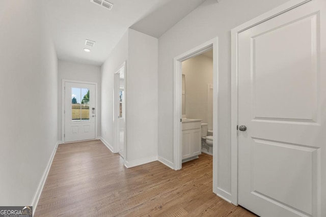 interior space with baseboards, visible vents, and light wood-style floors