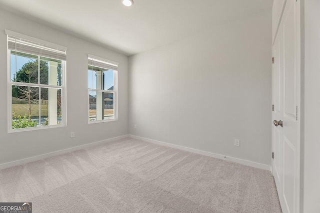 carpeted empty room featuring baseboards