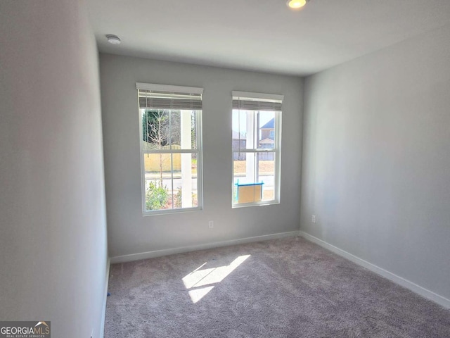 carpeted spare room with baseboards