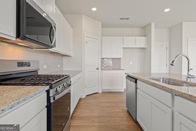 kitchen featuring appliances with stainless steel finishes, visible vents, a sink, and white cabinetry