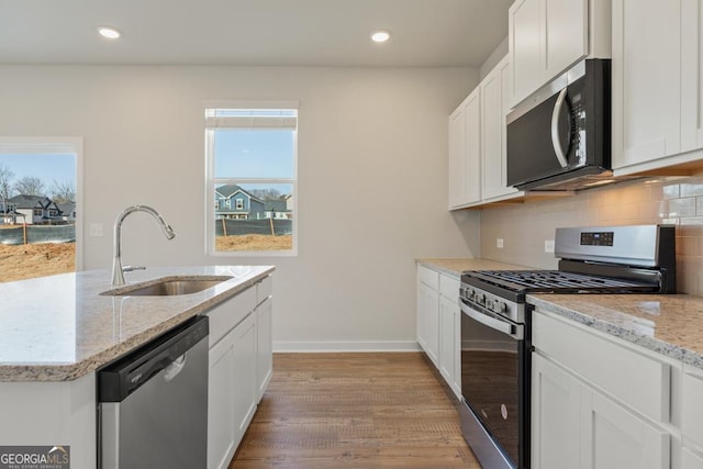 kitchen with plenty of natural light, decorative backsplash, stainless steel appliances, and a sink