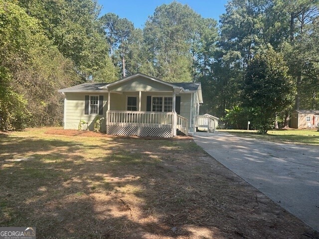 view of front of property featuring a shed, a front yard, and covered porch