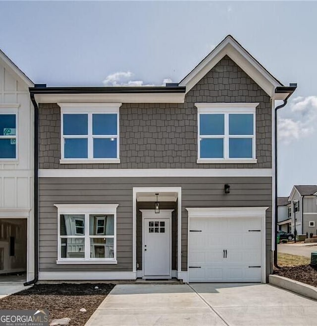 multi unit property featuring a garage and driveway