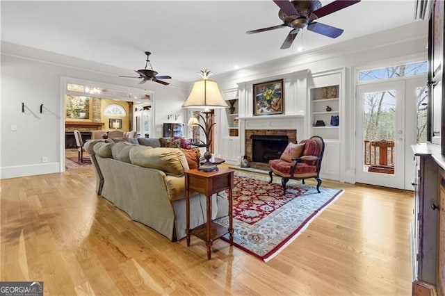 interior space featuring lofted ceiling with beams, a ceiling fan, wood finished floors, and a fireplace