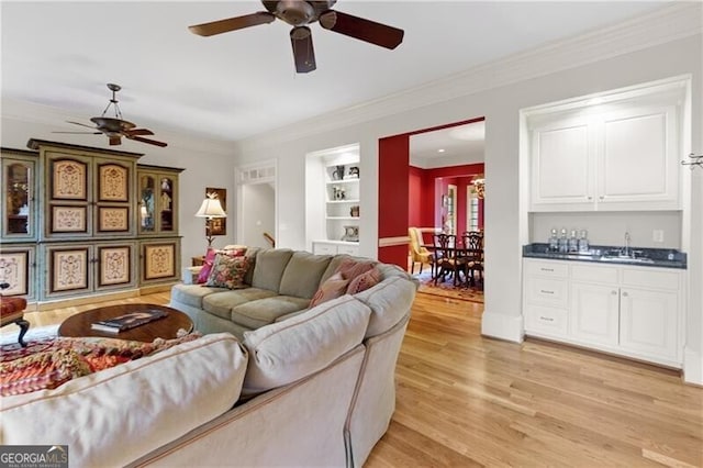 living area with a fireplace, french doors, ceiling fan, and ornamental molding