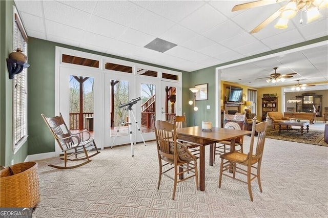 dining area featuring light carpet, ceiling fan, french doors, and a drop ceiling