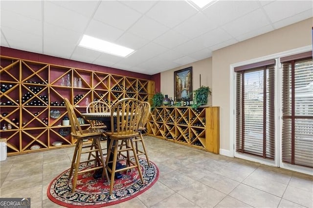 wine room with tile patterned flooring and a drop ceiling