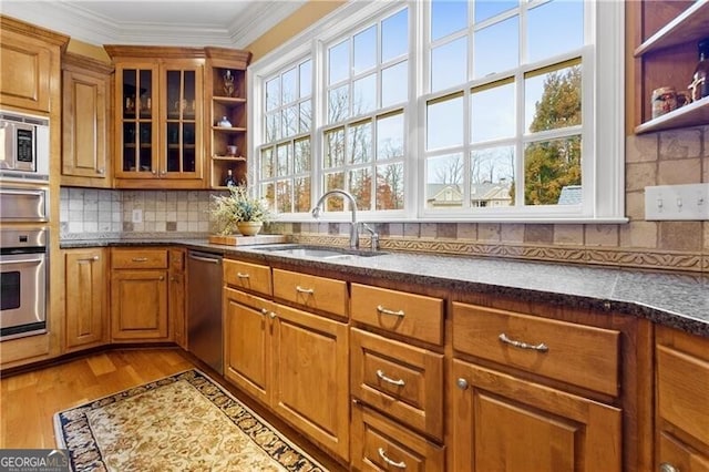 kitchen with brown cabinets, a chandelier, open shelves, light wood-style flooring, and appliances with stainless steel finishes