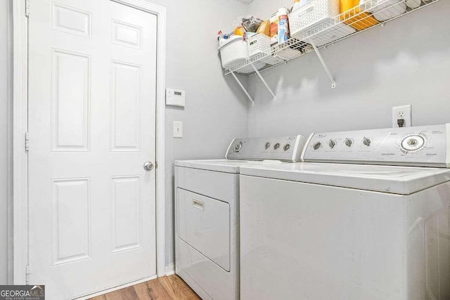 laundry room featuring light hardwood / wood-style floors and washing machine and clothes dryer