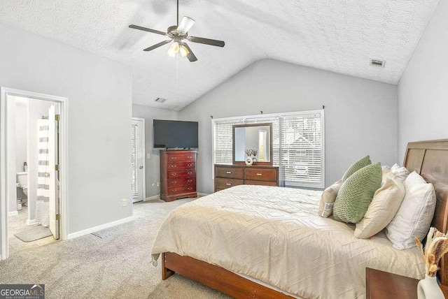 bedroom featuring vaulted ceiling, ensuite bath, ceiling fan, light carpet, and a textured ceiling