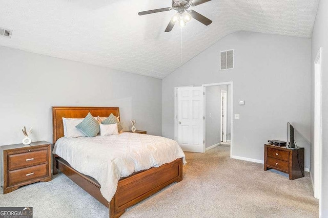 bedroom with light carpet, ceiling fan, vaulted ceiling, and a textured ceiling