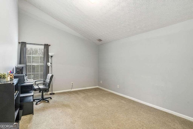 office space featuring vaulted ceiling, light carpet, and a textured ceiling