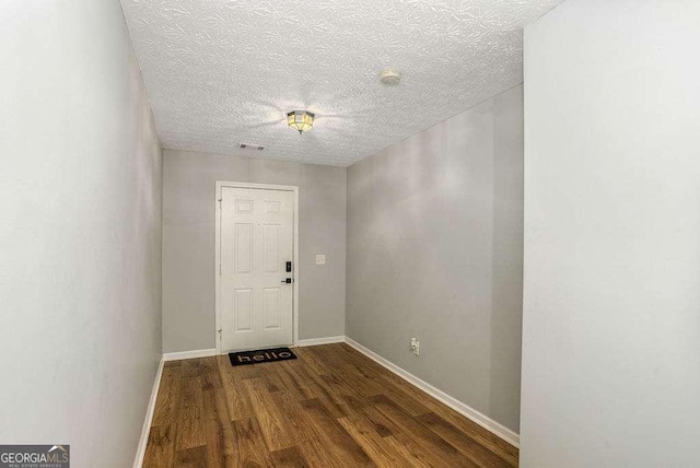 entrance foyer with dark wood-type flooring and a textured ceiling