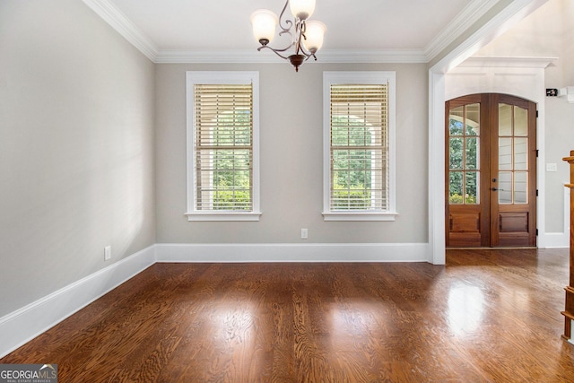 entrance foyer featuring a chandelier, ornamental molding, wood finished floors, and baseboards
