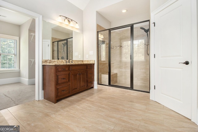 bathroom with a shower stall, vanity, and baseboards
